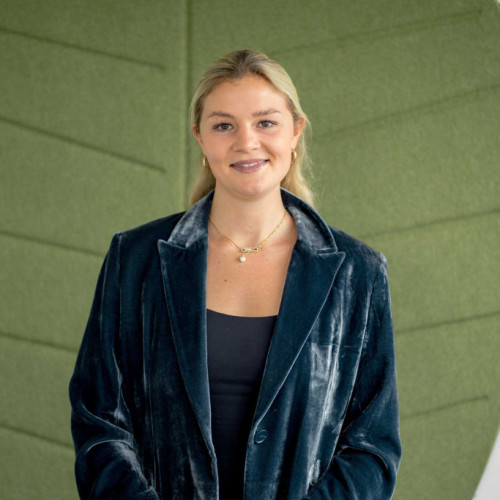 Lena Scharr stehend vor einem grünen Hintergrund