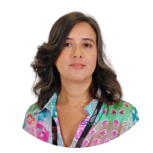 a woman in her 30s with dark hair wearing a colorful shirt